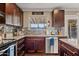 Kitchen with granite countertops, dark wood cabinets and stainless steel appliances at 1637 N Bridalwreath St, Tempe, AZ 85288