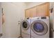 Laundry room with washer, dryer, and ample cabinet space at 16916 W Eureka Springs Dr, Surprise, AZ 85387