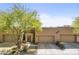 Tan stucco exterior with a three-car garage and lush landscaping at 17025 E La Montana Dr # 130, Fountain Hills, AZ 85268