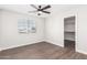 Bedroom with wood-look floors, ceiling fan, and walk-in closet at 224 S 151St Ave, Goodyear, AZ 85338