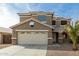 Two-story house with beige exterior, a large garage, and a palm tree at 224 S 151St Ave, Goodyear, AZ 85338