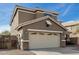 Two-story house with beige exterior, a large garage, and a well-maintained front yard at 224 S 151St Ave, Goodyear, AZ 85338
