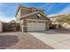 Two-story house with beige exterior, a large garage, and a well-maintained front yard at 224 S 151St Ave, Goodyear, AZ 85338
