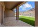 Expansive covered back patio leading to a green backyard with landscaped surroundings at 32470 N 134Th Ln, Peoria, AZ 85383