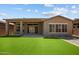 Beautifully landscaped backyard with lush artificial grass and an inviting covered patio at 32470 N 134Th Ln, Peoria, AZ 85383