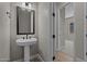 Charming powder room with a pedestal sink, decorative mirror and stylish fixtures at 32470 N 134Th Ln, Peoria, AZ 85383