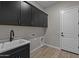 Well-equipped laundry room with ample cabinet space, countertop and a sink at 32470 N 134Th Ln, Peoria, AZ 85383