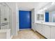 Bright bathroom featuring a glass enclosed shower, double sink vanity, and decorative blue accent wall at 4188 E Lexington Ave, Gilbert, AZ 85234
