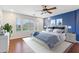 Bright bedroom with a large window, hardwood floors, and a calming blue accent wall for a relaxing retreat at 4188 E Lexington Ave, Gilbert, AZ 85234