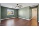Large bedroom with a ceiling fan, wood laminate flooring, and a view into the hallway at 4188 E Lexington Ave, Gilbert, AZ 85234