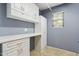 Laundry room featuring built-in cabinets, a folding counter, and a gray accent wall at 4188 E Lexington Ave, Gilbert, AZ 85234