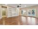 Spacious living room with hardwood floors, built-in shelving, ceiling fan, and access to the backyard through French doors at 4188 E Lexington Ave, Gilbert, AZ 85234