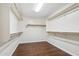 Spacious walk-in closet with wood laminate flooring and ample wooden shelf and rod storage space at 4188 E Lexington Ave, Gilbert, AZ 85234