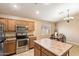 Kitchen with island, stainless steel appliances, and wood cabinets at 45513 W Sky Ln, Maricopa, AZ 85139