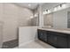 Sleek bathroom with dual sinks, modern fixtures, a tiled shower with glass enclosure, and a separate soaking tub at 5525 N 193Rd Dr, Litchfield Park, AZ 85340