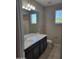 Well-lit bathroom with a single sink vanity, tile floors, and a window for natural light at 6516 W Madre Del Oro Dr, Phoenix, AZ 85083