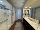 Hallway bathroom featuring a double sink vanity, large mirror, and a tiled shower at 6516 W Madre Del Oro Dr, Phoenix, AZ 85083