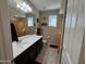 Well-lit bathroom featuring a dark vanity, neutral tile floors, and decorative fish accents at 6516 W Madre Del Oro Dr, Phoenix, AZ 85083