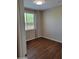 Cozy bedroom with wood flooring, neutral walls, and a window providing natural light at 6516 W Madre Del Oro Dr, Phoenix, AZ 85083