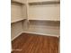 Walk-in closet featuring wood flooring, built-in shelving, and a hanging rod at 6516 W Madre Del Oro Dr, Phoenix, AZ 85083