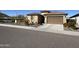 Charming single Gathering home featuring a tan exterior, brown garage door and low maintenance desert landscaping at 6516 W Madre Del Oro Dr, Phoenix, AZ 85083