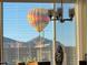 A hot air balloon hovers in view behind the blinds at 6516 W Madre Del Oro Dr, Phoenix, AZ 85083