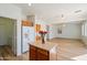 Kitchen features wood cabinets, island, and view into living room at 6917 W St. Charles Ave, Laveen, AZ 85339