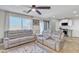 Living room featuring gray reclining sofas, a ceiling fan and view into the kitchen at 8072 W Georgetown Way, Florence, AZ 85132