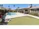 Spacious backyard with a pool, patio, lush landscaping, and an artificial lawn at 8631 E Vista Dr, Scottsdale, AZ 85250