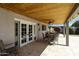 Covered patio features tongue and groove ceiling, a ceiling fan, and outdoor dining at 8631 E Vista Dr, Scottsdale, AZ 85250