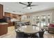 A dining area with views of the kitchen and the backyard, illuminated by a modern ceiling fan at 8631 E Vista Dr, Scottsdale, AZ 85250