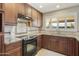 Traditional-style kitchen featuring wood cabinetry, granite countertops, and stainless steel appliances at 8631 E Vista Dr, Scottsdale, AZ 85250