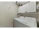 Laundry room with washer, dryer, and overhead cabinets at 8631 E Vista Dr, Scottsdale, AZ 85250