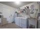 Bright laundry room features washer, dryer, utility sink, and ample storage at 9821 W Cedar Dr, Sun City, AZ 85351