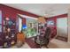 Relaxing sitting area with a comfortable recliner, TV, and shelving unit, offering ample natural light at 9821 W Cedar Dr, Sun City, AZ 85351