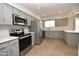 Updated kitchen with stainless steel appliances and light gray cabinets at 10331 W Willie Low Cir, Sun City, AZ 85351