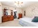 Serene bedroom with a ceiling fan, dresser, and double bed at 10461 W Devonshire Ave, Phoenix, AZ 85037