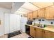 Galley style kitchen with white appliances and wood cabinets at 10461 W Devonshire Ave, Phoenix, AZ 85037