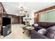 Living area featuring a fireplace, sectional sofa, and wood paneling at 10461 W Devonshire Ave, Phoenix, AZ 85037