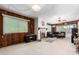 Spacious living room with fireplace, wood paneling, and large windows at 10461 W Devonshire Ave, Phoenix, AZ 85037