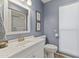 White bathroom vanity with a sink and toilet, featuring a large mirror and window at 10631 W Brookside Dr, Sun City, AZ 85351