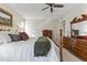 Primary bedroom with a queen bed, dresser, and ceiling fan, creating a restful and inviting space at 10631 W Brookside Dr, Sun City, AZ 85351