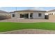 View of the backyard featuring a covered patio, artificial turf and low-maintenance landscaping at 12316 W Parkway Ln, Avondale, AZ 85323