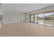 Open-concept living room with wood-look tile floors and a large sliding glass door with covered patio view at 12316 W Parkway Ln, Avondale, AZ 85323