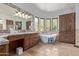 Luxurious bathroom with freestanding tub, granite vanity, and large mirror at 14179 E Kalil Dr, Scottsdale, AZ 85259