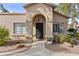 Tan stucco home with arched entryway, landscaping, and walkway at 14300 W Bell Rd # 326, Surprise, AZ 85374