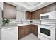 Bright kitchen features wood cabinets, white appliances, and gray tile floors at 14821 N 60Th Dr, Glendale, AZ 85306