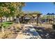 Community area with shaded picnic tables and playground at 16224 W La Ventilla Way, Goodyear, AZ 85338