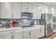 Modern kitchen with white cabinets, stainless steel appliances and mosaic backsplash at 16224 W La Ventilla Way, Goodyear, AZ 85338