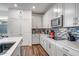 Modern kitchen with white cabinets, stainless steel appliances and mosaic backsplash at 16224 W La Ventilla Way, Goodyear, AZ 85338